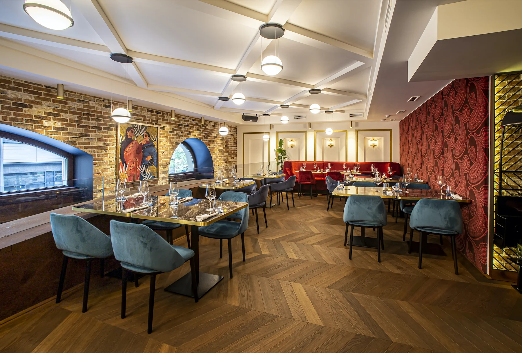 The first-floor dining room with a brick wall and turquoise chairs