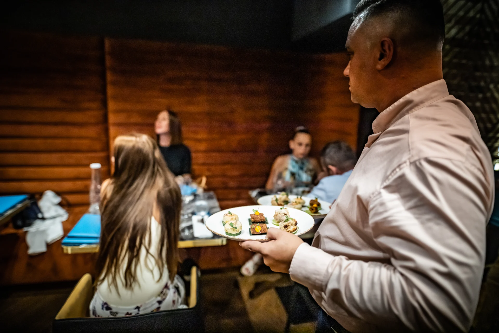 A server bringing food to a guest table